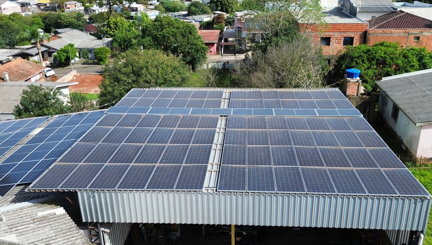 Vista aérea de painéis solares cobrindo telhado de galpão